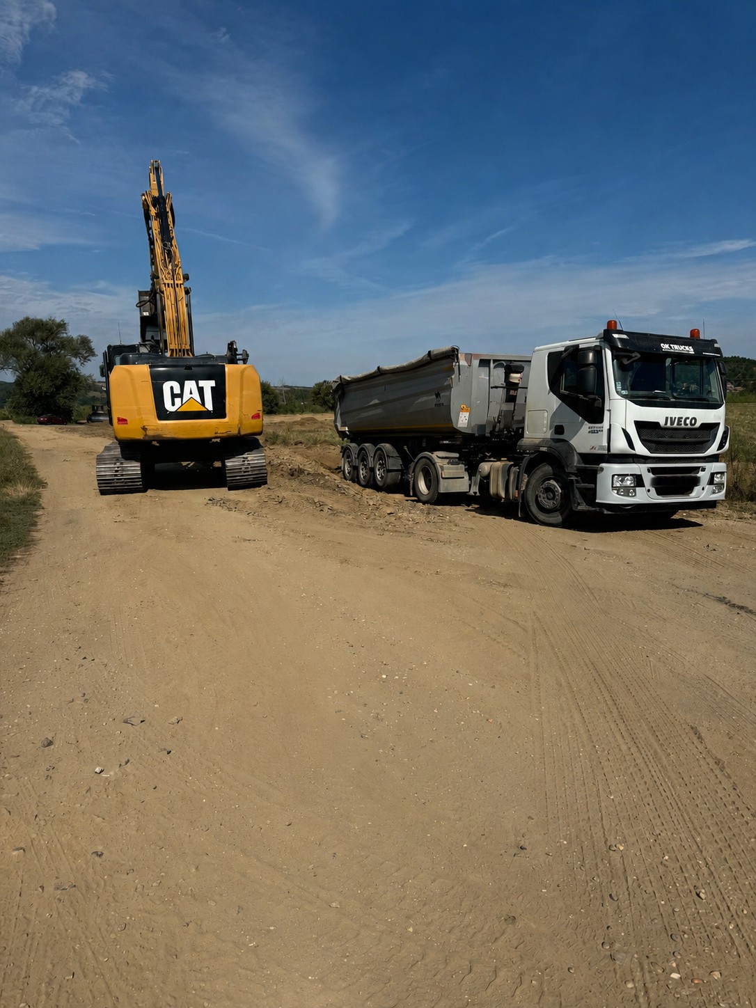 CAT kotró és IVECO teherautó munkaterületen